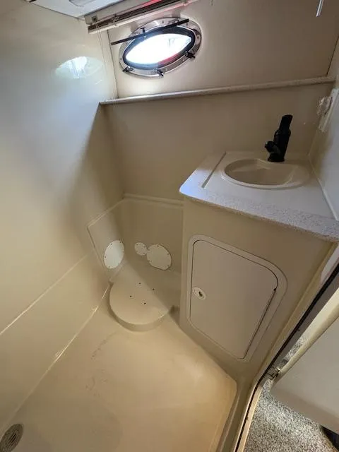 Slide: The Image of 1998 Cruisers 3870 Express boat bathroom with sink and porthole window. - 28