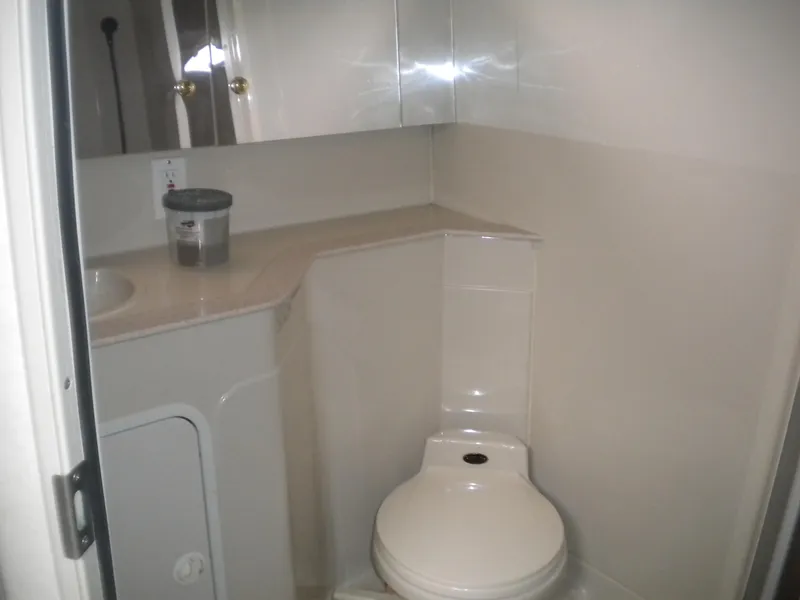 Slide: The Image of 1998 Cruisers 3870 Express yacht bathroom with toilet and mirrored cabinet. - 33