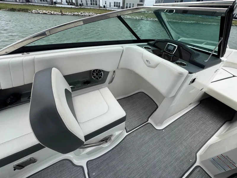 Slide: The Image of 2016 Chaparral 227 SSX boat interior with seating and dashboard, near water. - 11