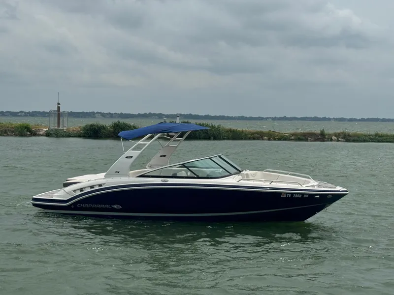 Slide: The Image of 2016 Chaparral 227 SSX boat on a lake with a blue canopy. - 4