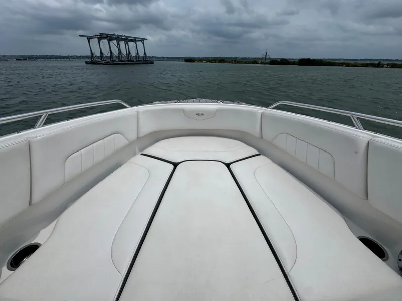Slide: The Image of 2016 Chaparral 227 SSX boat interior with white seating, on a cloudy day at sea. - 5
