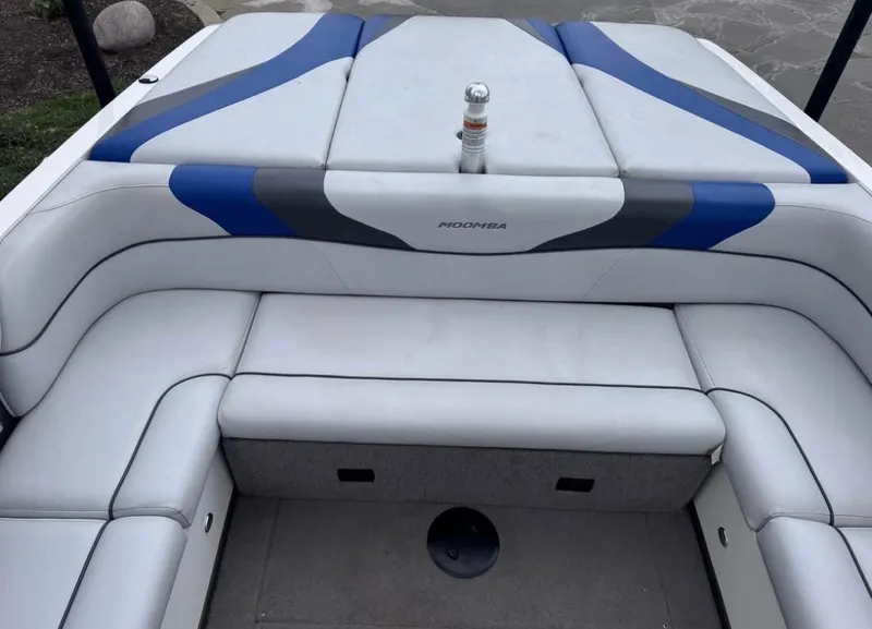 Slide: The Image of 2010 Moomba LSV boat interior with blue and gray accents, featuring cushioned seating. - 10