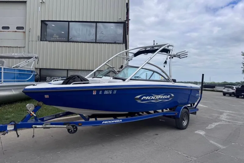 Slide: The Image of 2010 Moomba LSV boat on trailer, parked outside a building. - 2