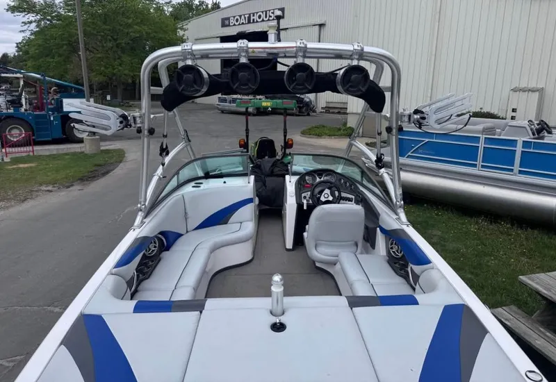 Slide: The Image of 2010 Moomba LSV boat with blue and gray interior, parked near a boat house. - 3