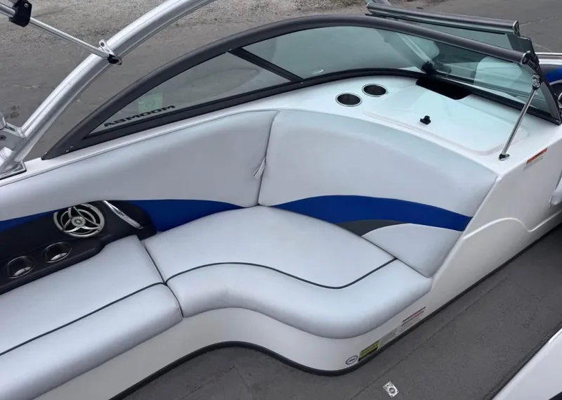 Slide: The Image of 2010 Moomba LSV boat interior with white and blue seating, cup holders, and speaker. - 8