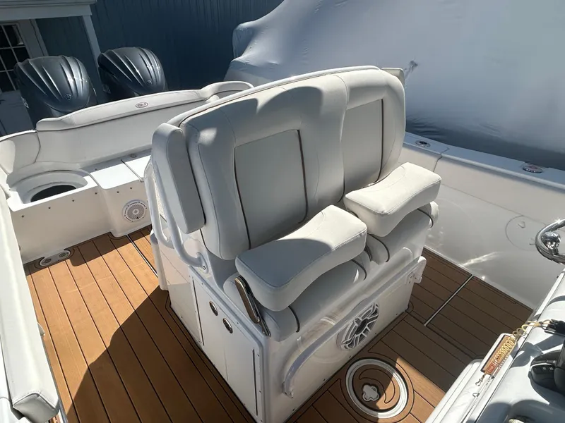 Slide: The Image of 2022 Sea Hunt Ultra 275 SE boat interior with cushioned seating and teak flooring. - 12