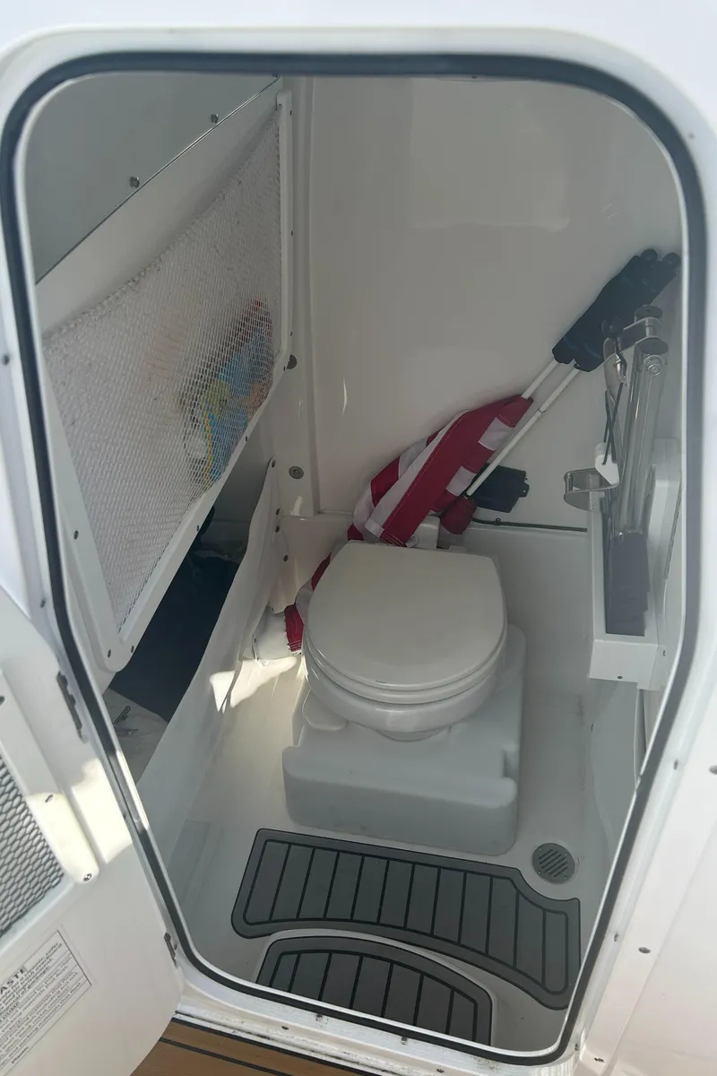 Slide: The Image of 2022 Sea Hunt Ultra 275 SE boat interior with compact marine toilet. - 18