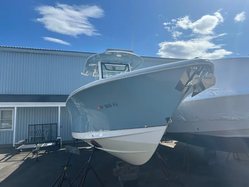 Slide: The Image of 2022 Sea Hunt Ultra 275 SE boat displayed outdoors under a clear blue sky. - 19