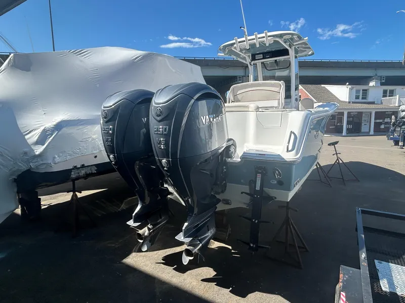 Slide: The Image of 2022 Sea Hunt Ultra 275 SE boat with dual Yamaha outboard engines, docked outdoors. - 2
