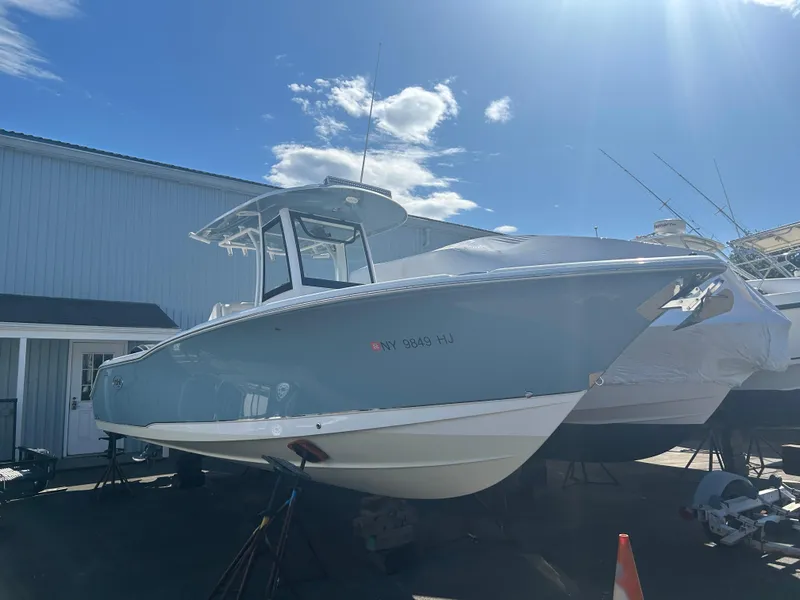 Slide: The Image of 2022 Sea Hunt Ultra 275 SE boat displayed outdoors under clear sky. - 20