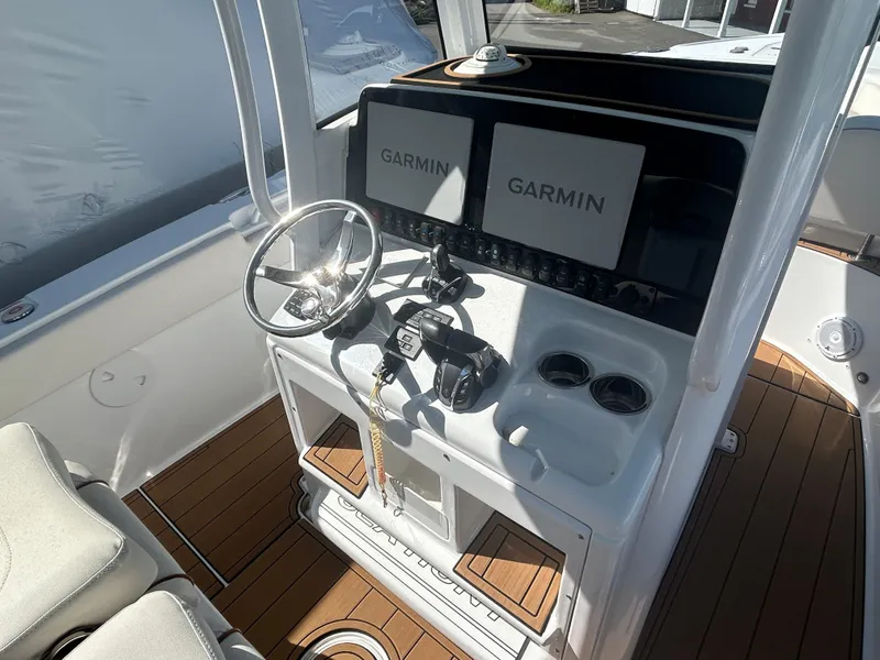 Slide: The Image of 2022 Sea Hunt Ultra 275 SE boat console with Garmin displays and steering wheel. - 4