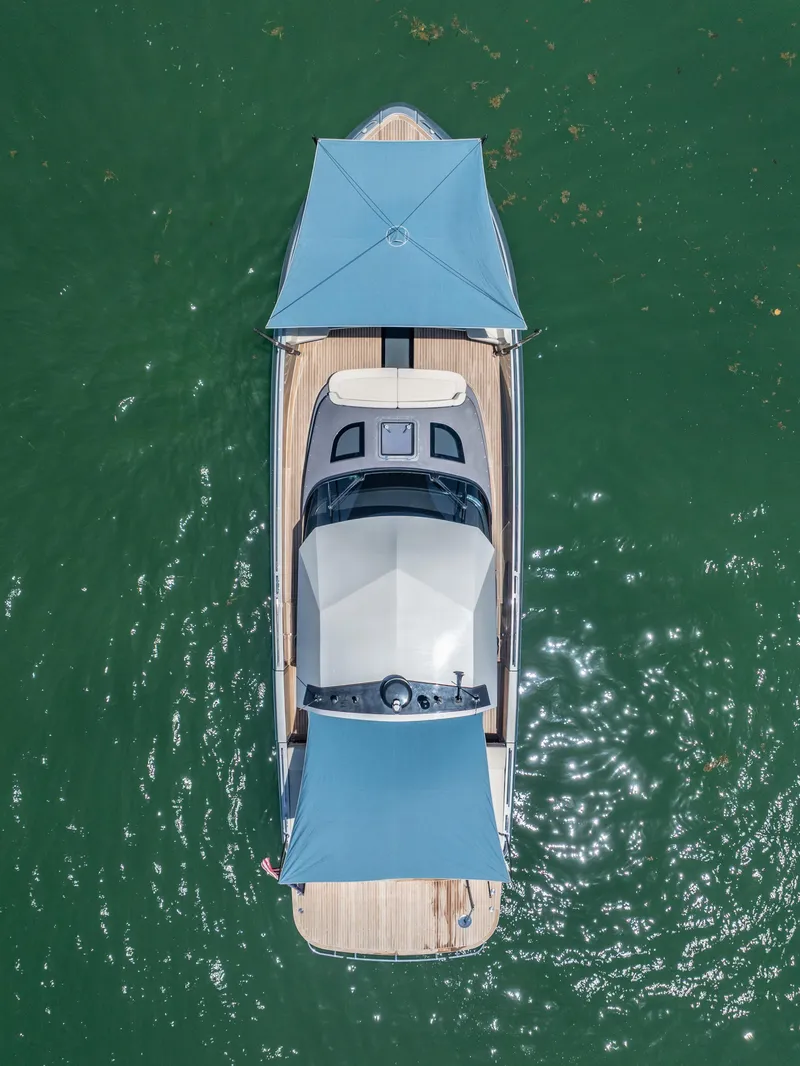 Slide: The Image of Aerial view of 2019 CNM Continental 54T yacht with blue canopies on green water. - 11