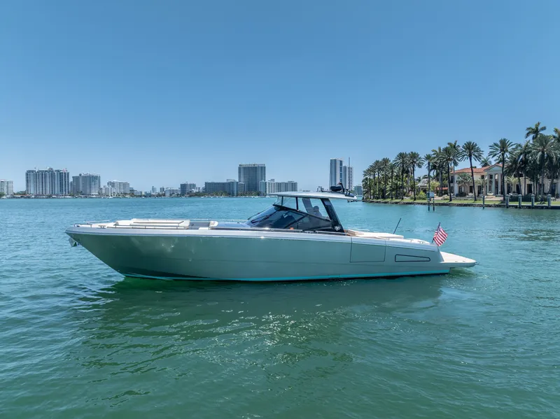 Slide: The Image of 2019 CNM Continental 54T yacht cruising on a sunny day near a city skyline. - 2