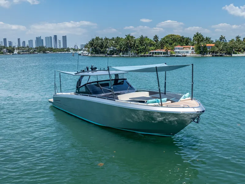 Slide: The Image of 2019 CNM Continental 54T yacht on serene water with city skyline and palm trees. - 6