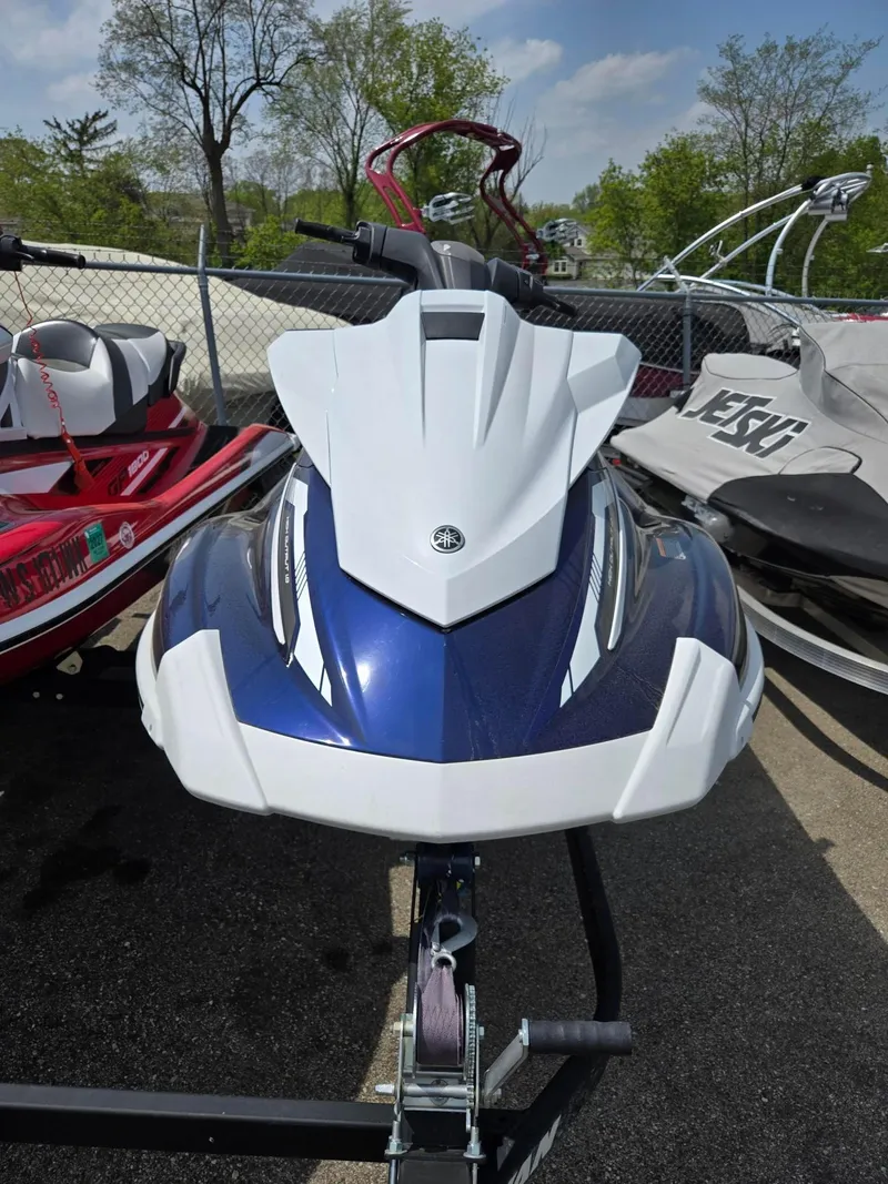 Slide: The Image of 2018 Yamaha Boats VX110 jet ski, blue and white, parked outdoors. - 4