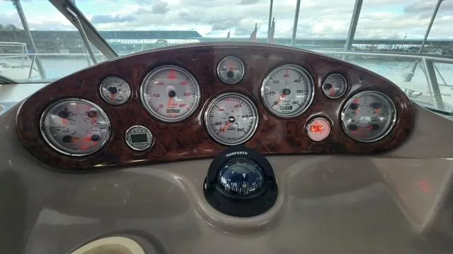 Slide: The Image of 2005 Rinker Fiesta Vee 342 dashboard with gauges and compass, overlooking marina. - 10
