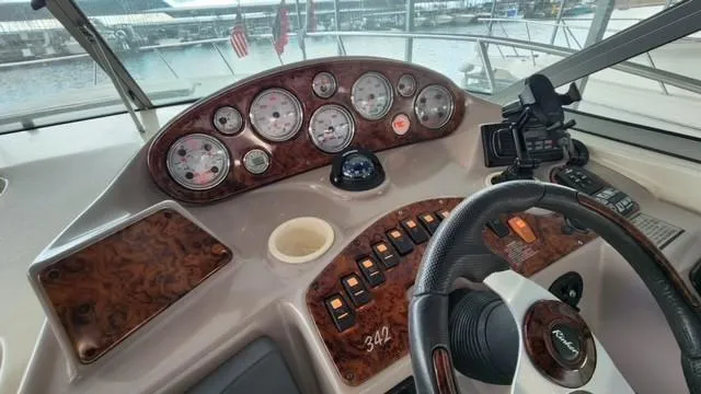 Slide: The Image of 2005 Rinker Fiesta Vee 342 dashboard with gauges and controls, overlooking marina. - 11