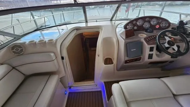 Slide: The Image of 2005 Rinker Fiesta Vee 342 cockpit with steering wheel, seating, and cabin entrance. - 13