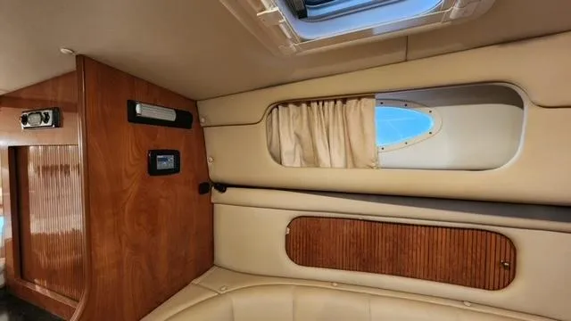 Slide: The Image of 2005 Rinker Fiesta Vee 342 cabin interior with wood paneling and porthole window. - 15