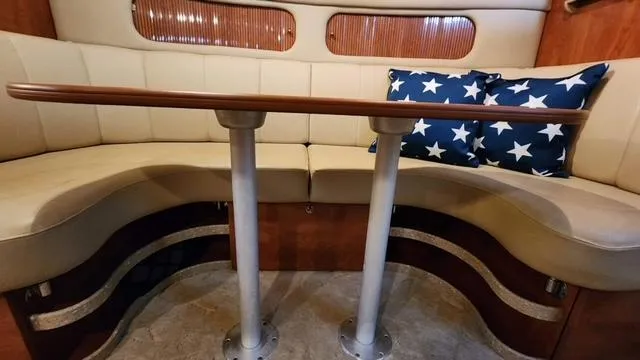 Slide: The Image of Interior of 2005 Rinker Fiesta Vee 342 with curved seating and star-patterned pillows. - 17