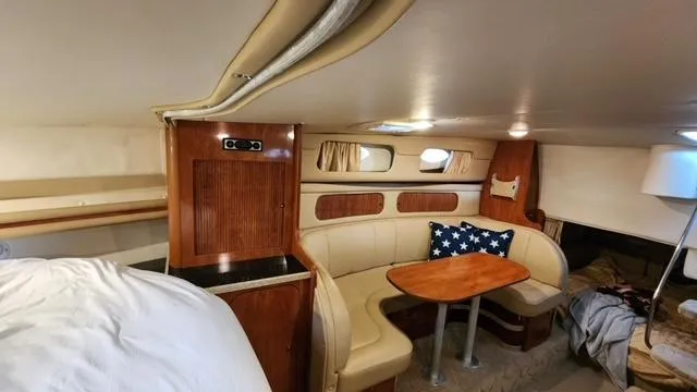 Slide: The Image of 2005 Rinker Fiesta Vee 342 cabin interior with seating and wooden table. - 19