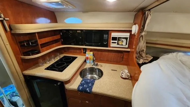 Slide: The Image of 2005 Rinker Fiesta Vee 342 boat interior with kitchenette and cozy sleeping area. - 20