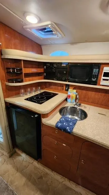 Slide: The Image of 2005 Rinker Fiesta Vee 342 boat kitchen with stove, sink, and microwave. - 21