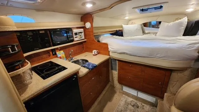 Slide: The Image of 2005 Rinker Fiesta Vee 342 cabin interior with kitchenette and bed. - 22