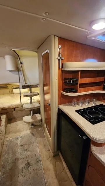 Slide: The Image of 2005 Rinker Fiesta Vee 342 cabin interior with kitchenette and sleeping area. - 28