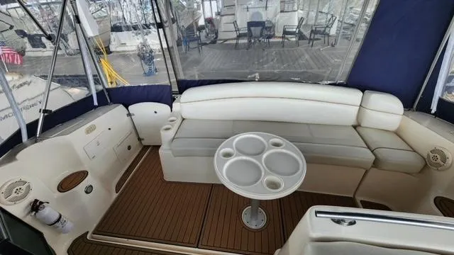 Slide: The Image of 2005 Rinker Fiesta Vee 342 boat interior with seating and table in a marina setting. - 5