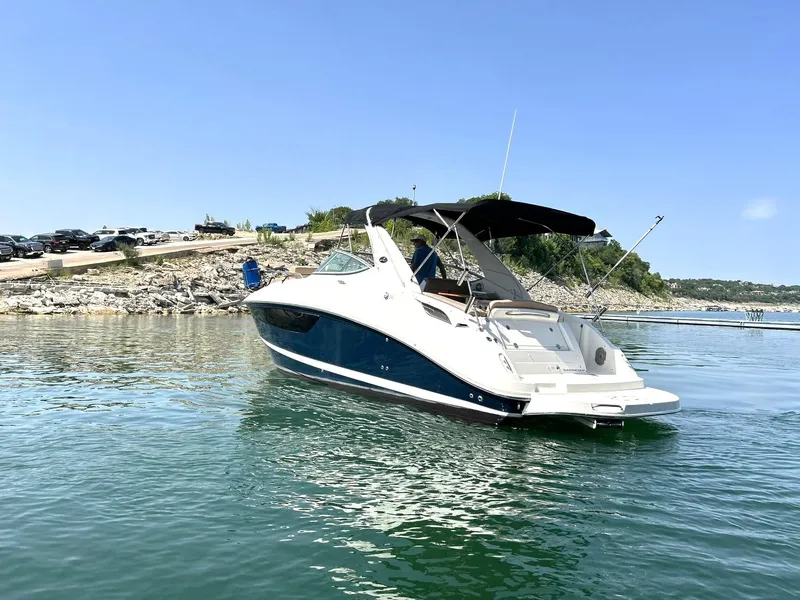 Slide: The Image of 2017 Sea Ray 280 Sundancer boat on calm water, sunny day, rocky shoreline. - 10
