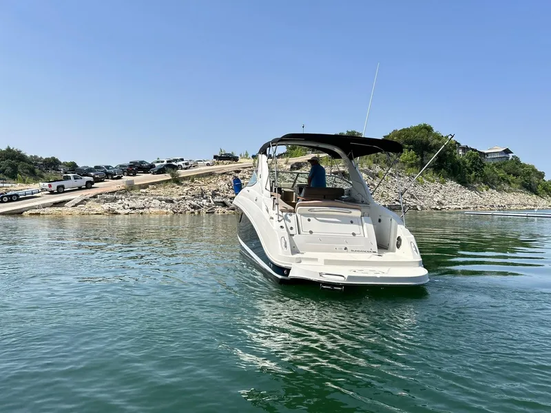 Slide: The Image of 2017 Sea Ray 280 Sundancer boat on calm water near rocky shoreline. - 11