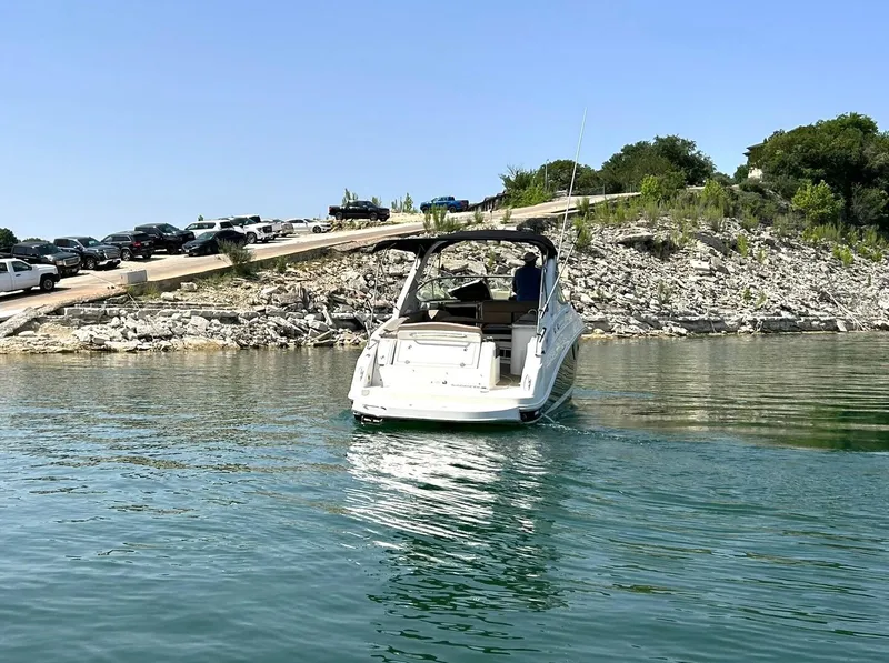 Slide: The Image of Sea Ray 280 Sundancer 2017 boat on calm water near rocky shoreline. - 13