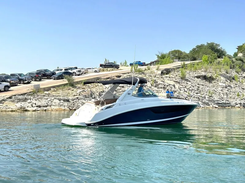 Slide: The Image of 2017 Sea Ray 280 Sundancer boat on calm water near rocky shoreline. - 14