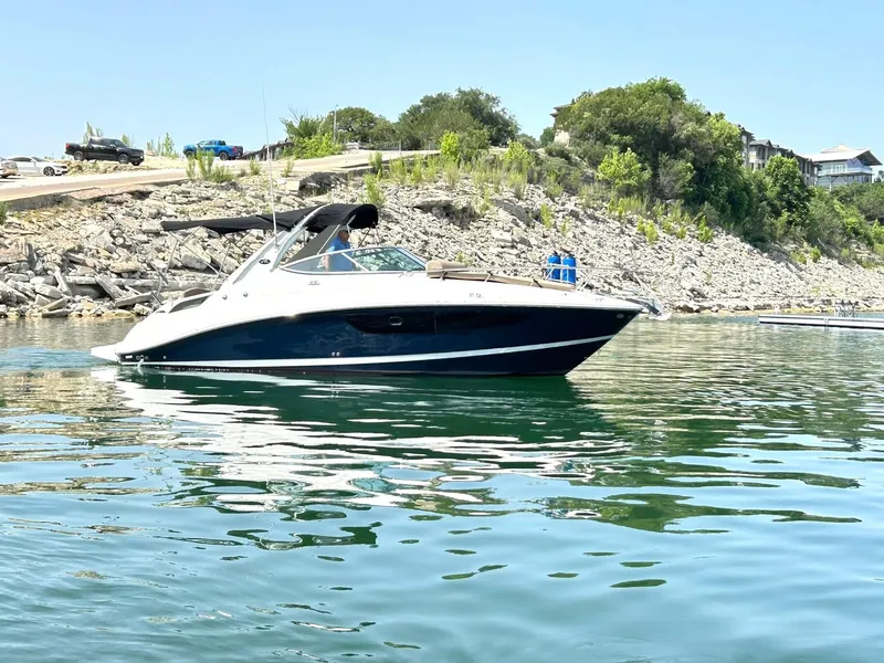Slide: The Image of 2017 Sea Ray 280 Sundancer boat on calm water near rocky shoreline. - 15