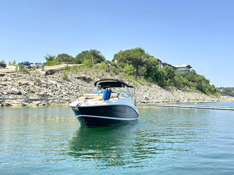 Slide: The Image of 2017 Sea Ray 280 Sundancer boat on calm water near rocky shoreline. - 20