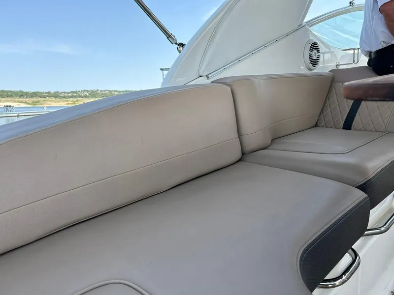 Slide: The Image of 2017 Sea Ray 280 Sundancer boat interior with beige seating and scenic water view. - 28