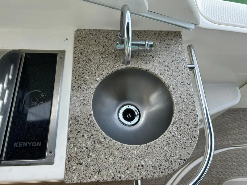 Slide: The Image of 2017 Sea Ray 280 Sundancer boat sink and Kenyon cooktop in the galley area. - 45