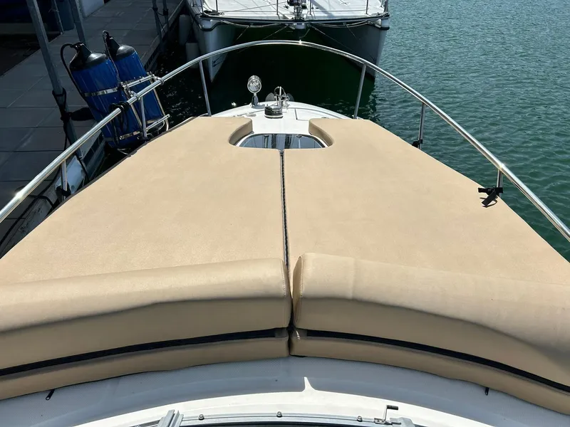 Slide: The Image of 2017 Sea Ray 280 Sundancer boat with beige sunpad on deck, docked by the water. - 46