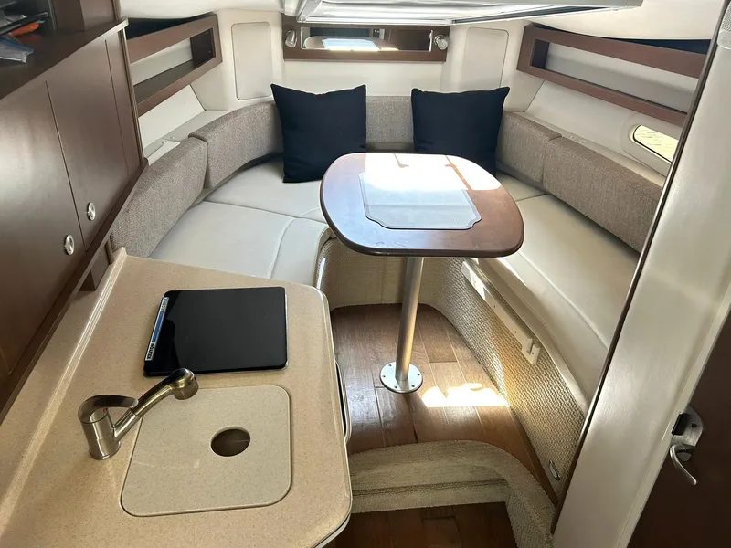 Slide: The Image of 2017 Sea Ray 280 Sundancer cabin with seating, table, and kitchenette. - 6