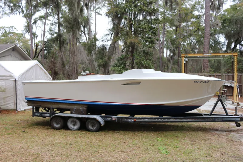 The Image of 2018 Blackfin Custom 25 boat on trailer, parked outdoors near trees. - 1