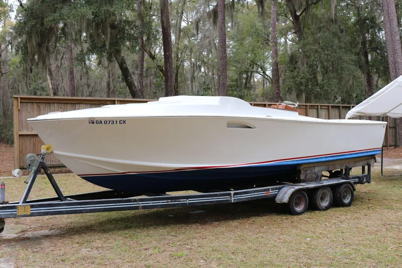 Slide: The Image of 2018 Blackfin Custom 25 boat on trailer, parked outdoors near trees. - 2