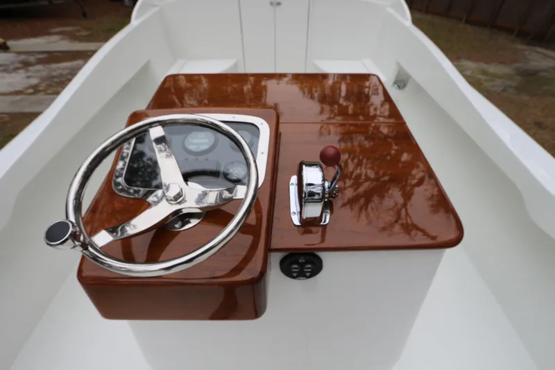 Slide: The Image of 2018 Blackfin Custom 25 boat helm with polished wood finish and steering wheel. - 5