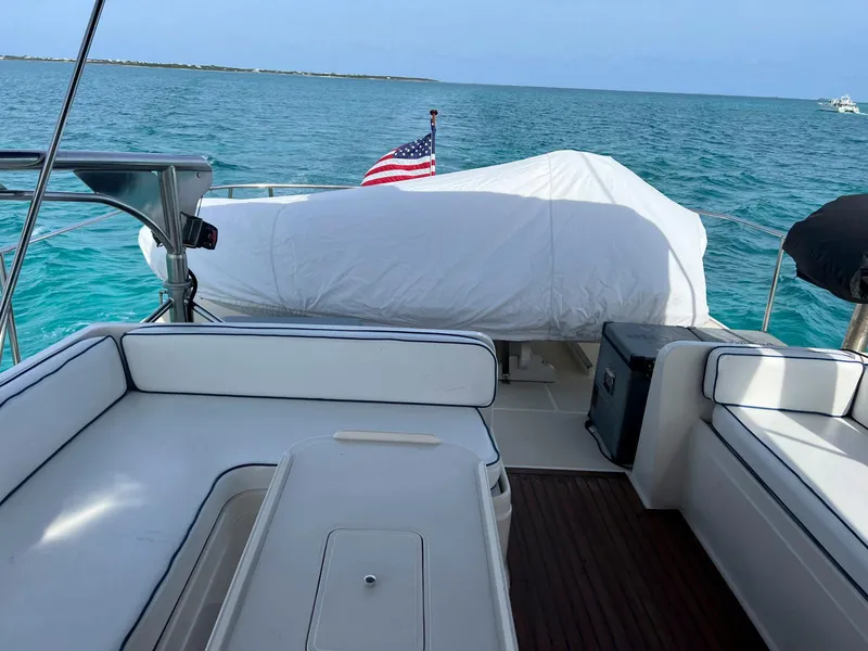 Slide: The Image of 1990 Fleming 50 yacht deck with seating, American flag, and ocean view. - 13