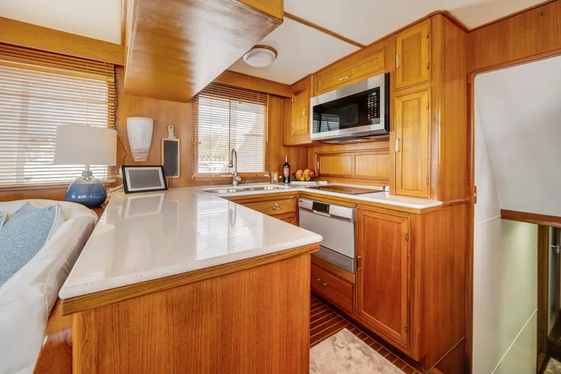 Slide: The Image of Luxurious 1990 Fleming 50 yacht kitchen with wood cabinetry and modern appliances. - 17