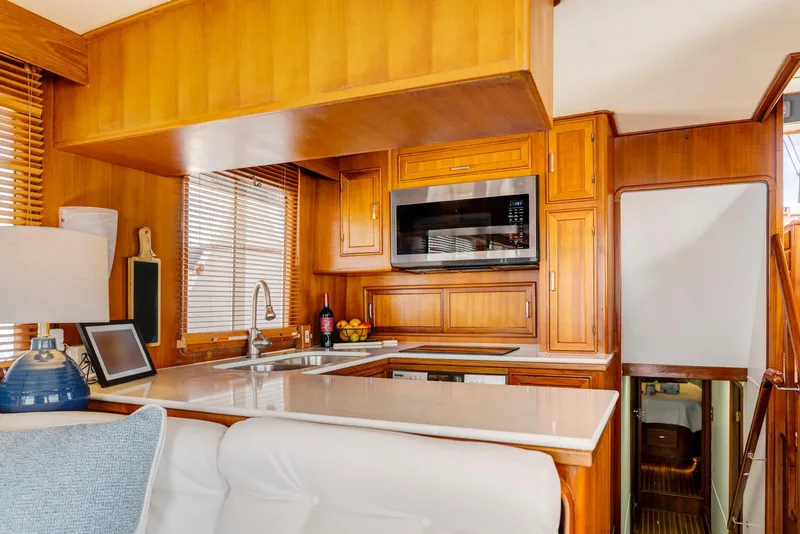 Slide: The Image of Luxurious 1990 Fleming 50 yacht kitchen with wood cabinetry and modern appliances. - 18