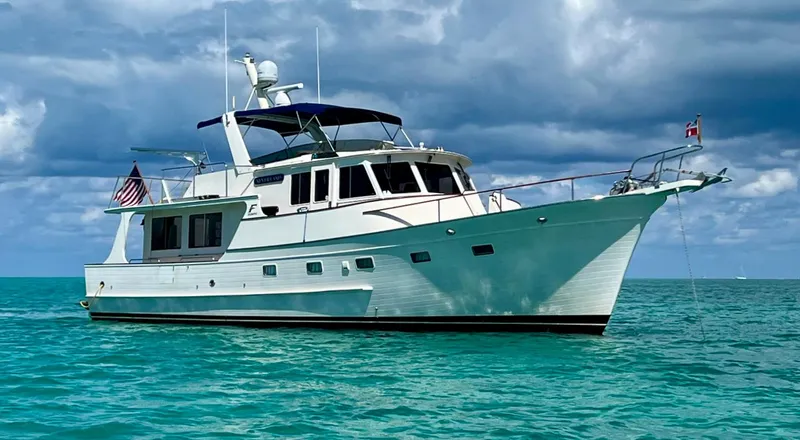 Slide: The Image of Fleming 50 yacht from 1990 on calm turquoise waters under cloudy skies. - 2