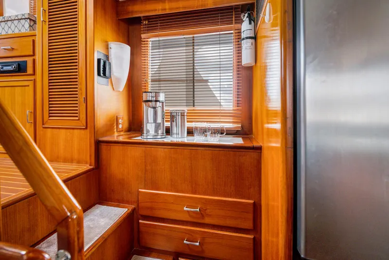Slide: The Image of Wood-paneled interior of a 1990 Fleming 50 yacht with drawers and a window. - 20