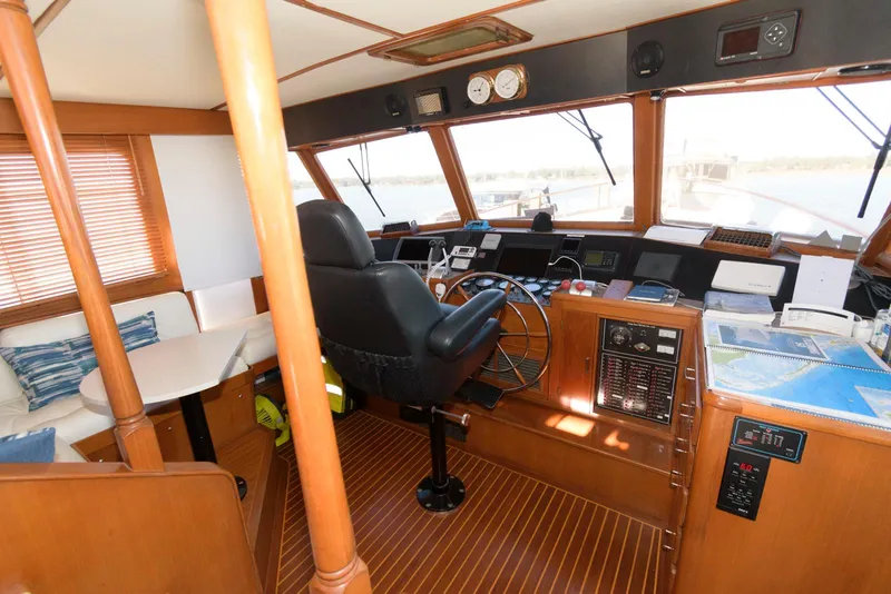 Slide: The Image of 1990 Fleming 50 yacht helm with wooden interior, steering wheel, and navigation equipment. - 21