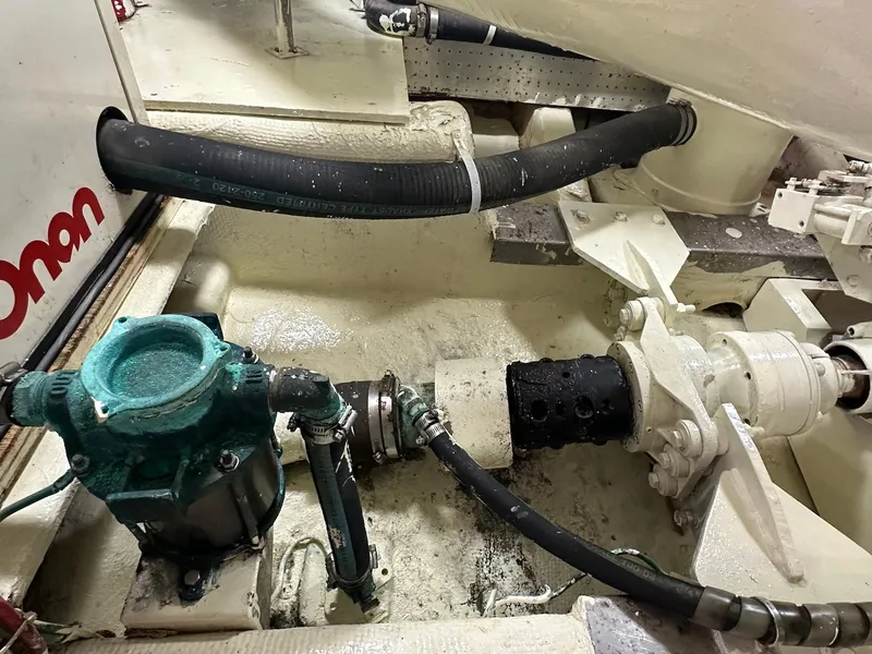 Slide: The Image of Engine room of a 1990 Fleming 50 yacht, featuring mechanical components and hoses. - 44